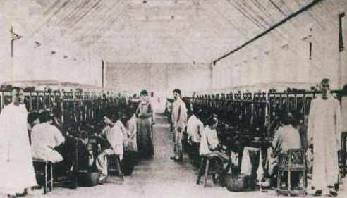 怡和纱厂车间，图中洋男女即纱厂洋经理及妻子。两边站立者即被称为“那摩温”的工头